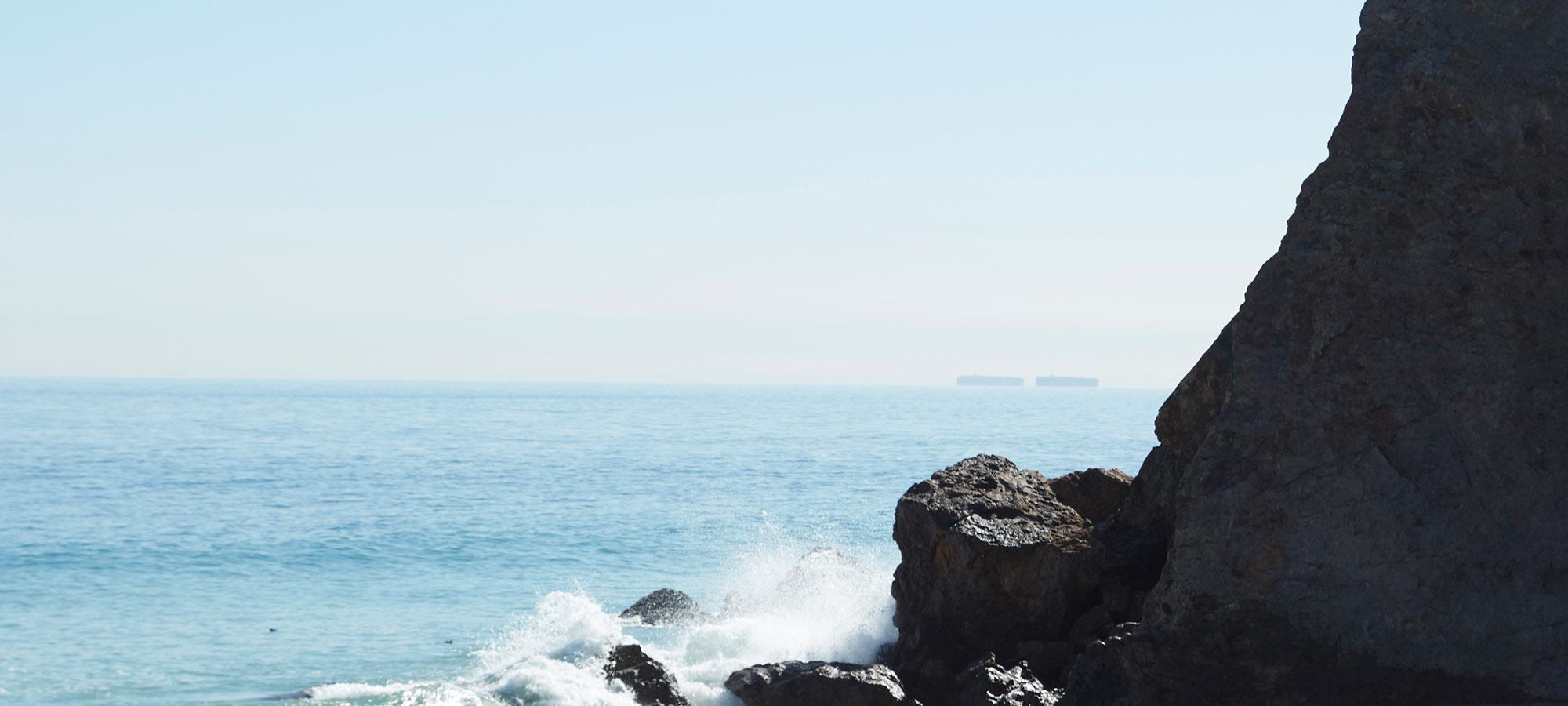 Zumbido, ondas de uma praia quebrando em uma rocha